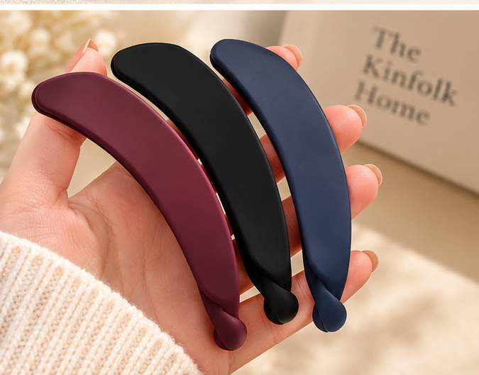 Three matte banana hair clips shown in hand